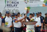 Plt Gubernur Jambi Fachrori Umar (kedua kanan) dan Kapolda Irjen Pol Muchlis (kedua kiri) didampingi Sekda Dianto (kanan) dan Wali Kota Jambi Syarif Fasha (kiri) memegang obor api Asian Games 2018 di lapangan Kantor Gubernur Jambi, Telanaipura, Jambi, Jumat (3/8/2018). Api yang sebelumnya dikirab ke kawasan percandian Muarajambi dan Kota Jambi tersebut selanjutnya dibawa menuju Palembang, Sumatera Selatan. (ANTARA FOTO/Wahdi Septiawan) 