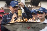 Penjabat Gubernur Jawa Barat M Iriawan membawa Api Obor Asian Games 2018 saat prosesi Torch Relay di Gedung Sate, Bandung, Jawa Barat, Minggu (12/8). Api Obor Asian Games 2018 tersebut selanjutnya diarak dari Gedung Sate menuju Garut. ANTARA JABAR/M Agung Rajasa/agr/18
