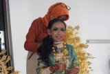 Seorang ibu peserta JFC Kids memasang aksesoris pada kostum putrinya yang mengenakan busana defile India di Kantor Pemerintah Kabupaten Jember, Jawa Timur, Kamis (9/8). Ratusan anak-anak tampil dengan mengenakan kostum 10 defile dalam Kids Carnival JFC yang melewati 