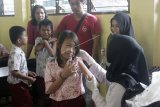 Seorang siswa ketakutan saat diberikan imunisasi Campak dan Rubella (MR) oleh petugas kesehatan di SD Inpres 113 Kota Sorong, Papua Barat, Rabu (29/8). Sempat ditolak sejumlah pihak, Imunisasi MR di Papua Barat mencapai peringkat pertama dari 28 Provinsi untuk cakupan kumulatif Imunisasi MR sebesar 70,22 persen dan diharapkan terus meningkat pada bulan September 2018. ANTARA FOTO/Olha Mulalinda/STR