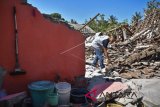 Seorang warga membersihkan puing-puing rumahnya yang roboh pascagempa di Desa Padak Guar, Kecamatan Sambelia, Lombok Timur, NTB, Senin (20/8). Pascagempa bumi yang berkekuatan 7 Skala Richter mengguncang Lombok pada Minggu malam pukul 22.56 Wita mengakibatkan sejumlah rumah di daerah tersebut roboh dan puluhan warga mengungsi. ANTARA FOTO/Ahmad Subaidi/wdy/2018