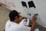 Ilustrator, Budi Kurniawan membuat mural Soekarno-Hatta di dinding tembok Gang Suka Jaya, Pontianak, Kalbar, Senin (13/8). Pembuatan mural tersebut untuk menyambut HUT ke-73 Kemerdekaan Republik Indonesia. ANTARA FOTO/Jessica Helena Wuysang/18