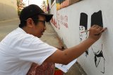 Ilustrator, Budi Kurniawan membuat mural Soekarno-Hatta di dinding tembok Gang Suka Jaya, Pontianak, Kalbar, Senin (13/8). Pembuatan mural tersebut untuk menyambut HUT ke-73 Kemerdekaan Republik Indonesia. ANTARA FOTO/Jessica Helena Wuysang/18