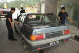 Tiga petugas Bea dan Cukai Entikong memeriksa mobil Malaysia di Pos Lintas Batas Negara (PLBN) Entikong di Kabupaten Sanggau, Kalbar, Sabtu (18/8). Pemeriksaan wajib oleh pihak Bea dan Cukai Entikong tersebut, untuk mencegah upaya penyelundupan barang ilegal seperti narkoba. ANTARA FOTO/HS Putra/jhw/18