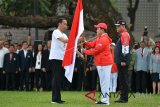 Presiden Joko Widodo (kiri) menyerahkan bendera Merah Putih kepada Ketua Komite Olahraga Indonesia (KOI) Erick Thohir (tengah) disaksikan CdM kontingen Indonesia, Komjen Pol Syafruddin saat upacara pelepasan di halaman tengah Kompleks Istana, Jakarta, Rabu (8/8). Presiden melepas 938 atlet dan 396 ofisial yang akan berlaga pada Asian Games 2018 dengan menargetkan minimal 16 medali emas atau masuk 10 besar. ANTARA FOTO/Wahyu Putro A/wdy/2018.