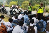 Sejumlah petugas kepolisian memberi nasehat kepada puluhan pelajar yang kedapatan sedang melakukan aksi konvoi menggunakan sepeda motor di Jalan Ahmad Yani Pontianak, Kalbar, Jumat (17/8). Aksi konvoi yang digelar pelajar menggunakan motor usai mengikuti upacara bendera HUT Kemerdekaan ke-73 RI tersebut, sangat rawan kecelakaan dan dapat membahayakan keselamatan para pelajar. ANTARA FOTO/Jessica Helena Wuysang/18