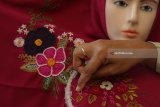 Perajin membuat hiasan jilbab dengan teknik sulam benang di Surabaya, Jawa Timur, Selasa (7/8). Jilbab berhias sulam benang dengan berbagai motif itu dijual di pasaran dengan harga Rp65.000 sampai Rp95.000 per buah. Antara Jatim/Didik Suhartono/mas/18.