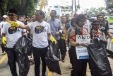 Gubernur Jawa Barat Ridwan Kamil (kiri) bersama Walikota Bogor Bima Arya (kedua kiri) dan relawan memungut sampah dalam Bebersih Bogor di pedestrian kawasan Tugu Kujang, Kota Bogor, Jawa Barat, Sabtu (15/9). Aksi Bebersih Bogor dalam rangka World Clean Up Day 2018 yang dilakukan serentak di 150 negara di dunia dan 34 propinsi di Indonesia tersebut untuk mengedukasi dan mengubah pola pikir serta prilaku masyarakat untuk tidak membuang sampah sembarang tempat. ANTARA JABAR/Arif Firmansyah/agr/18.