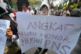 Sejumlah guru honorer yang tergabung dalam Forum Honorer K2 Indonesia (FHK2I) berunjuk rasa di depan kantor Pemkab Pamekasan, Jawa Timur, Kamis (20/9). Mereka menuntut pemerintah untuk mencabut Permenpan RB 36,37 2018 dan segera mengesahkan revisi UU ASN 2014. Antara Jatim/Saiful Bahri/mas/18.