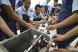 Sejumlah siswa SMK Prakarya Internasional (PI) membongkar mesin sepeda motor di SMK PI, Bandung, Jawa Barat, Selasa (4/9). Direktur Jenderal Pengelolaan Pembiayaan dan Risiko (DJPPR) Kementerian Keuangan, Luky Alfirman mengatakan pada tahun 2019 pemerintah mengalokasikan anggaran pendidikan vokasi senilai Rp 17,2 triliun sebagai bagian dari program revitalisasi pendidikan vokasi untuk peningkatan kualitas SDM dalam menghadapi dunia kerja. ANTARA JABAR/Raisan Al Farisi/agr18