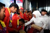 Gubernur Jawa Timur terpilih Khofifah Indar Parawansa (kedua kanan) didampingi Wakil Gubernur Jawa Timur terpilih Emil Elestianto Dardak (kanan) berjabat tangan dengan atlet sepak takraw Saiful RIjal (ketiga kiri) peraih medali emas di ajang Asian Games 2018 diarak dengan kendaraan seni asal Madura dalam Tasyakuran Relawan Khofifah-Emil di Surabaya, Jawa Timur, Sabtu (8/9). Apresiasi tersebut diberikan pada atlet dan offisial peraih medali di Asian Games 2018. Antara Jatim/M Risyal Hidayat/mas/18.