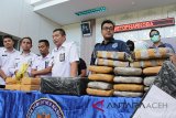 Kepala Badan Narkotika Nasional Provinsi Aceh, Brigjen Pol Faisal Abdul Naser, (ketiga kanan) memperlihatkan barang bukti tindak kejahatan narkotika berupa enam bungkus sabu seberat enam kilogram dan puluhan bungkus ganja saat gelar kasus di Banda Aceh, (27/9). BNN Aceh berhasil mengagalkan peredaran sabu seberat enam kilogram yang dipasok dari Malaysia melalui Aceh, sebelum diedarkan ke Batam dan Jakarta serta barang bukti lainnya, ganja seberat 150 kilogram dan mengamankan dua tersangka (Antara Aceh/Ampelsa/18)