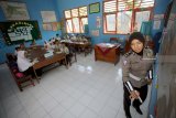 Anggota polwan mengajar di salah satu sekolah dasar negeri (SDN) di Blitar, Jawa Timur, Rabu (26/9). Polres Blitar menerjunkan personel untuk membantu proses belajar mengajar disejumlah SD hingga SMA yang sampat lumpuh sejak Senin (24/9) salu akibat aksi mogok sejumlah Guru Tidak Tetap (GTT) yang memprotes program rekrutmen CPNS 2018. Antara Jatim/Irfan Anshori/mas/18.