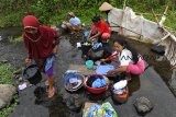 Warga beraktivitas mencuci baju dan piring di aliran Sungai Ciwulan Kampung Tamansari, di Tasikmalaya, Jawa Barat, Selasa (25/9). Musim kemarau berkepanjangan menyebabkan sejumlah warga melakukan aktivitas Mandi Cuci Kakus (MCK) di aliran sungai yang sudah tercemar limbah karena sumber air milik warga di kampung itu sudah mengering sejak tiga bulan terakhir. ANTARA JABAR/Adeng Bustomi/agr/18