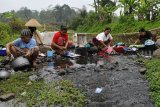 Warga beraktivitas mencuci baju dan piring di aliran Sungai Ciwulan Kampung Tamansari, di Tasikmalaya, Jawa Barat, Selasa (25/9). Musim kemarau berkepanjangan menyebabkan sejumlah warga melakukan aktivitas Mandi Cuci Kakus (MCK) di aliran sungai yang sudah tercemar limbah karena sumber air milik warga di kampung itu sudah mengering sejak tiga bulan terakhir. ANTARA JABAR/Adeng Bustomi/agr/18