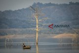 Seorang nelayan mencari ikan di Waduk Jatigede, Kabupaten Sumedang, Jawa Barat, Kamis (6/9). Akibat musim kemarau, debit air Waduk Jatigede mengalami penyusutan hingga 60.700 meter kubik yang telah terjadi selama tiga bulan. ANTARA JABAR/Raisan Al Farisi/agr/18