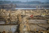 Sejumlah anak bermain diantara sisa bangunan yang tampak ke permukaan di Waduk Jatigede, Kabupaten Sumedang, Jawa Barat, Kamis (6/9). Akibat musim kemarau, debit air Waduk Jatigede mengalami penyusutan hingga 60.700 meter kubik yang telah terjadi selama tiga bulan. ANTARA JABAR/Raisan Al Farisi/agr/18