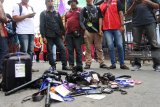 Sejumlah wartawan melakukan demonstrasi dengan meletakkan ID kartu pers dan kamera di Jalan Raya Ledokombo, Jember, Jawa Timur, Sabtu (22/9). Aksi ini dilakukan sebagai bentuk kekecewaan terhadap oknum Dinas Pariwisata Jember karena melarang wartawan untuk masuk lokasi Festival Egrang ke-9 yang digelar Tanoker dan dihadiri Menteri Pemberdayaan Perempuan dan Perlindungan Anak Yohana Yembise. Antara Jatim/Seno/mas/18.