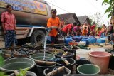 Sejumlah warga Desa Geger, Kecamatan Kedungadem, Bojonegoro, Jawa Timur, antre air bersih yang didistribusikan Badan Penanggulangan Bencana Daerah (BPBD) setempat, Kamis (20/9). Dampak musim kemarau kesulitan air bersih sekarang ini melanda 13.017 kepala keluarga (KK) yang tersebar di 43 desa di 13 kecamatan. Antarajatim/Slamet Agus Sudarmojo/18. 