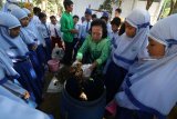 Sejumlah siswa SD Plus Rahmat mengamati cara pembuatan pupuk organik di Bank Sampah Sri Wilis, Kelurahan Pojok, Kota Kediri, Jawa Timur, Senin (24/9). Praktek pembuatan pupuk dari sampah organik dan menanam tanaman tersebut bertujuan mengedukasi pelajar agar mencintai sekaligus menjaga lingkungan hidup sejak dini. Antara Jatim/Prasetia Fauzani/mas/18.