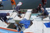Pekerja memasukkan es balok ke perahu nelayan di Pelabuhan Kalbut, Mangaran, Situbondo, Jawa Timur, Rabu (19/9). Sejumlah nelayan harus menambah pasokan es balok di musim kemarau untuk mengawetkan ikan hasil tangkap, dari 1000 menjadi 1500 balok, sehingga biaya produksi pun bertambah. Antara Jatim/Seno/mas/18.