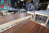 Pekerja menyelesaikan pembuatan meja berbahan limbah kayu palet pesanan pelanggan di industri rumahan Raja Woodworking di Surabaya, Jawa Timur, Minggu (16/9). Limbah kayu palet yang dibuat menjadi furniture sesuai pesanan tersebut dijual dengan harga mulai Rp1,5 juta hingga Rp2,5 juta per set tergantung tingkat kerumitan desain pembuatannya. Antara jatim/Moch Asim/zk/18.