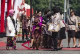 Ibu Negara Iriana Joko Widodo (tengah) disaksikan Ibu Asuh Polwan Tri Tito Karnavian (kiri) berjabat tangan dengan Polwan berprestasi pada peringatan HUT Ke-70 Polwan di Monas, Jakarta, Senin (3/9). Kegiatan yang dihadiri oleh 2.000 pasukan perempuan yang terdiri dari Polwan, Wanita TNI, ASN Perempuan pada Polri, Satpol PP Perempuan, Dinas Perhubungan dan Pramuka itu mengangkat tema 'Polwan Promoter Siap Menyukseskan Agenda Kamtibmas Tahun 2018 dan 2019'. ANTARA FOTO/Aprillio Akbar/wdy/2018.