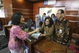 Direktur Utama Bank BJB Ahmad Irfan (kanan) didampingi Direktur Operasional Fermiyanti (kedua kanan), Direktur Konsumer dan Ritel Suartini (kedua kiri) melayani nasabah dengan memberikan bunga dan cinderamata pada Hari Pelanggan Nasional 2018 di kantor cabang utama Bandung Bank BJB, Kota Bandung, Jawa Barat, Selasa (4/9). Bank BJB memberikan apresiasi di Hari Pelanggan Nasional ini kepada seluruh nasabah yang telah memberikan kepercayaan kepada bank BJB untuk menjadi mitra bisnis dalam layanan keuangan perbankan serta lebih mendekatkan Bank BJB dengan nasabah. ANTARA JABAR/Heru Salim/agr/18