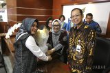 Direktur Utama Bank BJB Ahmad Irfan (kanan) didampingi Direktur Operasional Fermiyanti (kedua kiri), Direktur Konsumer dan Ritel Suartini (kedua kanan) melayani nasabah dengan memberikan bunga dan cinderamata pada Hari Pelanggan Nasional 2018 di kantor cabang utama Bandung Bank BJB, Kota Bandung, Jawa Barat, Selasa (4/9). Bank BJB memberikan apresiasi di Hari Pelanggan Nasional ini kepada seluruh nasabah yang telah memberikan kepercayaan kepada bank BJB untuk menjadi mitra bisnis dalam layanan keuangan perbankan serta lebih mendekatkan Bank BJB dengan nasabah. ANTARA JABAR/Heru Salim/agr/18