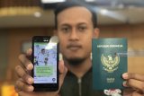 Pemohon menunjukkan pesan pendek dari sistem Passport Reminder saat pengambilan paspor di Kantor Imigrasi Kelas II Blitar, Jawa Timur, Kamis (27/9). Guna meningkatkan kualitas pelayanan, Imigrasi Blitar sedang mengujicoba sistem pemberitahuan berbasis pesan pendek bernama Passport Reminder. Antara Jatim/Irfan Anshori/mas/18.