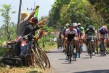 Komunitas sepedah ontel memberikan semangat pada Pebalap sepeda saat beradu kecepatan pada kejuaraan International Tour de Banyuwangi Ijen (ITDBI) di Banyuwangi, Jawa Timur, Kamis (27/9). Etape kedua ITdBI 2018 start di Stasiun Kalibaru dan finish di depan Kantor Bupati Banyuwangi sepanjang 179,3 kilometer. Antara Jatim/Budi Candra Setya/mas/18. 