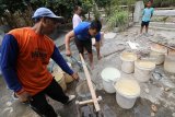 Warga mengambil air bersih dari salah satu sumur warga di Desa Balonggebang, Nganjuk, Jawa Timur, Selasa (18/9). Warga di daerah tersebut mengelungkan belum mendapatkan bantuan air bersih meskipun ratusan sumur telah mengering dalam empat bulan terakhir karena musim kemarau. Antara Jatim/Prasetia Fauzani/mas/18.