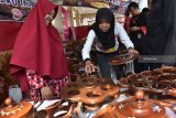 Pengunjung memilih hasil kerajinan berbahan kayu jati di sebuah stand pameran industri di Alun-alun Ponorogo, Jawa Timur, Kamis (6/9). Hasil kerajinan kayu jati dari Ngawi Jawa Timur tersebut dijual dengan harga antara Rp100 ribu hingga Rp400 ribu per set tergantung ukuran dan tingkat kesuliatan pembuatannya. Antara Jatim/Siswowidodo/mas/18.