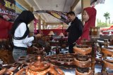 Pengunjung memilih hasil kerajinan berbahan kayu jati di sebuah stand pameran industri di Alun-alun Ponorogo, Jawa Timur, Kamis (6/9). Hasil kerajinan kayu jati dari Ngawi Jawa Timur tersebut dijual dengan harga antara Rp100 ribu hingga Rp400 ribu per set tergantung ukuran dan tingkat kesuliatan pembuatannya. Antara Jatim/Siswowidodo/mas/18.