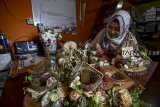 Perajin melakukan perekatan saat membuat kerajinan mahar dan hantaran di Kuchiwalang Art, Bandung, Jawa Barat, Rabu (19/9). Perajin menyatakan, kerajinan mahar dan hantaran yang dijual dari harga Rp 350 ribu hingga Rp 3 juta tersebut menjadi pilihan alternatif bagi muda-mudi yang akan melangsungkan pernikahan dengan desain mahar yang bervariasi. ANTARA JABAR/Raisan Al Farisi/agr/18