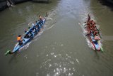 Peserta memacu kecepatan saat mengikuti lomba dayung perahu naga di Sungai Kalimas, Surabaya, Jawa Timur, Sabtu (8/9). Lomba yang diikuti 24 peserta dari berbagai universitas dan 20 tim pelajar SMA/SMK se-Jawa Timur tersebut guna mencari bibit atlet dayung terbaik. Antara Jatim/Moch Asim/18.