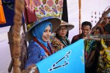 Menteri Pemberdayaan Perempuan dan Perlindungan Anak Yohana Yembise (kedua kiri), Bupati Jember Faida (kiri) melihat batik di Ledokombo Jember, Jawa Timur, Sabtu (22/9). Dalam kunjungannya Yohana Yembise melihat pameran produk kerajinan perempuan, seperti batik, kuliner tradisional yang sehat dan unik. Antara Jatim/Seno/mas/18.  