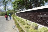 Pengunjung mengamati relief yang menggambarkan kekejaman PKI di areal Monumen Korban Keganasan PKI 1948 di Kresek, Kabupaten Madiun, Jawa Timur, Senin (17/9). Di lokasi tersebut anggota PKI membunuh secara kejam 17 orang tokoh pada saat terjadi pemberontakan PKI di Madiun pimpinan Muso pada 1948. Antara Jatim/Foto/Siswowidodo/zk/18