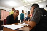 Sejumlah Pekerja Migran Indonesia (PMI) menjalani proses pendataan oleh petugas BP3TKI saat tiba di Dinas Sosial Provinsi Kalbar di Pontianak, Rabu (6/9) malam. BP3TKI Pontianak bersama P4TKI Entikong mencatat ada 45 PMI bermasalah yang dipulangkan Pemerintah Malaysia melalui PLBN Entikong, karena tidak memiliki ijin kerja dan paspor. ANTARA FOTO/Reza Novriandi/jhw/18