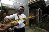 Petugas memasang garis polisi di rumah produksi ekstasi di Perumahan Sentra Pondok Rajeg, Cibinong, Bogor, Jawa Barat, Senin (24/9). Satuan Reserse Narkoba Polres Metro Jakarta Barat menggerebek pabrik ekstasi jenis baru dan mengamankan tiga orang tersangka dengan barang bukti 3000 butir ekstasi beserta alat dan bahan pembuatnya. ANTARA JABAR/Yulius Satria Wijaya/agr/18.