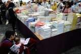 Pengunjung mengamati jajaran buku yang dijual pada pameran buku 