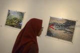 Pengunjung memperhatikan karya foto tentang Sungai Citarum yang dipamerkan di Galeri Soemardja, Bandung, Jawa Barat, Jumat (7/9). Pameran foto dengan tema 