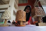Mahasiswi S1 jurusan Ilmu Hukum Universitas Muhammadiyah Surabaya (UMS) Auliya Septias menunjukkan kap lampu yang terbuat dari bonggol jagung saat Pameran Inovasi Kuliah Kerja Nyata (KKN) di Surabaya, Jawa Timur, Kamis (20/9). Pameran yang mengusung tema 