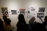 Pengunjung melihat karya berupa koran dan foto lama yang dipajang saat pameran Warisan Budaya dan Foto 