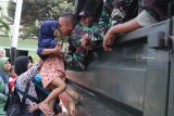 Seorang prajurit mencium anaknya di atas truk sebelum ditinggal bertugas di markas Batalyon Infanteri Yonif 521 Kota Kediri Jawa Timur, Jumat (31/8). Sebanyak 450 prajurit diberangkatkan ke Merauke Papua selama sembilan bulan guna mengamankan perbatasan Indonesia - Papua Nugini. Antara Jatim/Prasetia Fauzani/mas/18.