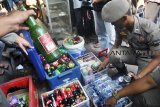 Petugas Satpol PP menunjukkan minuman keras saat pembongkaran kios penjual minuman keras di wilayah Bubulak, Kota Bogor, Jawa Barat, Jum'at (14/9). Petugas gabungan Satpol PP, Polresta Bogor Kota, TNI AD dan Dishub Kota Bogor diturunkan untuk membongkar 18 kios penjual minuman keras yang sering meresahkan warga dan mengganggu ketertiban umum karena dijadikan tempat mangkal bagi pelajar. ANTARA JABAR/Arif Firmansyah/agr/18