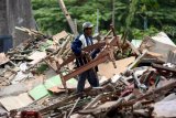 Pedagang mengevakuasi barang miliknya ketika berlangsungnya penertiban bangunan liar di kawasan Ngagel Surabaya, Jawa Timur, Kamis (20/9). Menurut data Satpol PP Provinsi Jawa Timur, sebanyak 109 lapak maupun bangunan liar tersebut dibongkar guna penertiban wilayah serta mempermudah Balai Besar Wilayah Sungai (BBWS) Brantas inspeksi sungai. Antara Jatim/M Risyal Hidayat/mas/18.