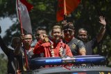 Peraih medali emas cabang olahraga silat dalam perhelatan Asian Games 2018 Hanifan Yudani Kusuma (tengah) menunjukkan medalinya saat pawai penyambutan di Bandung, Jawa Barat, Senin (3/9). Penyambutan yang diinisiasi oleh Ikatan Pencak Silat Indonesia (IPSI) Jabar tersebut dilakukan dalam rangka merayakan prestasi yang diraih oleh atlet silat Jabar yang meraih empat dari 14 medali emas dalam cabang olahraga silat. ANTARA JABAR/Raisan Al Farisi/agr/18.