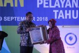 Menteri Pendayagunaan Aparatur Negara dan Reformasi Birokrasi (PANRB) Syafruddin (kiri) menyerahkan penghargaan kepada Wali Kota Surabaya Tri Rismaharini (kanan) saat acara Penyerahan Penghargaan Top 99 Inovasi Pelayanan Publik 2018 di Surabaya, Jawa Timur, Rabu (19/9). Pemberian penghargaan tersebut merupakan salah satu upaya pemerintah untuk terus mendorong terciptanya inovasi pelayanan publik guna meningkatkan kualitas pelayanan kepada masyarakat menjadi lebih baik. Antara Jatim/Moch Asim/18.