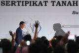 Presiden Joko Widodo (kiri) menaiki panggung untuk memberikan arahan saat penyerahan sertifikat tanah untuk rakyat di Surabaya, Kamis (6/9). Pemerintah menargetkan menyerahkan sertifikat tanah sebanyak 7 juta sertifikat tanah untuk rakyat selama 2018. Antara Jatim/Zabur Karuru/18
